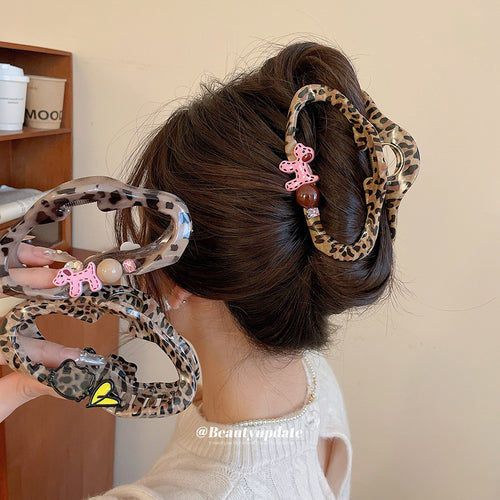 Leopard dog charm claw worn in bun with extra claws held