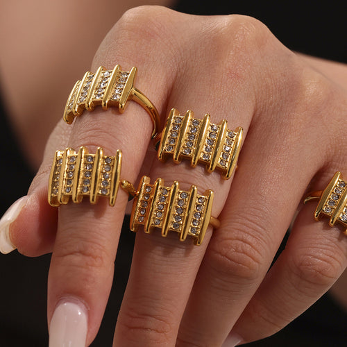 Multiple gold multi-bar zircon rings worn on fingers