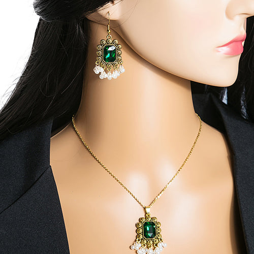 Green gem pendant necklace and drop earring worn on mannequin with black blazer