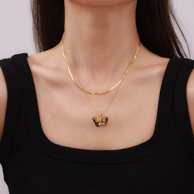 Model wearing gold butterfly pendant necklace with herringbone layering chain