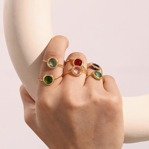 Hand wearing stack of multicolor Czech glass open rings
