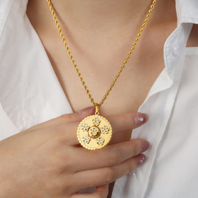 Model holding gold round crystal flower pendant on rope chain