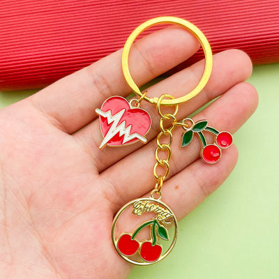 Image 1 showing a person holding up an apple keychain.
