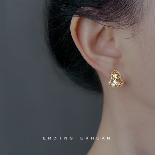Gold gourd stud earring worn on ear side profile