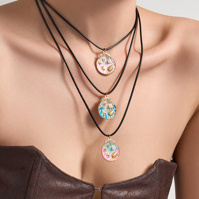 Model wearing three black cord enamel seashell pendant necklaces layered