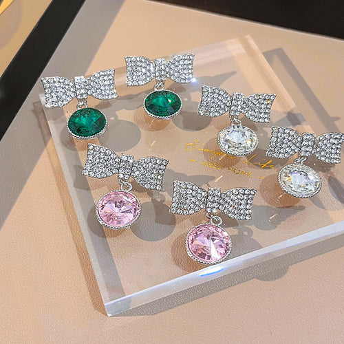 Crystal bow drop earrings green pink clear on acrylic display