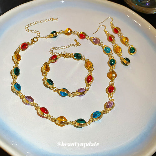 Gold multicolor oval cabochon necklace bracelet and drop earrings on plate