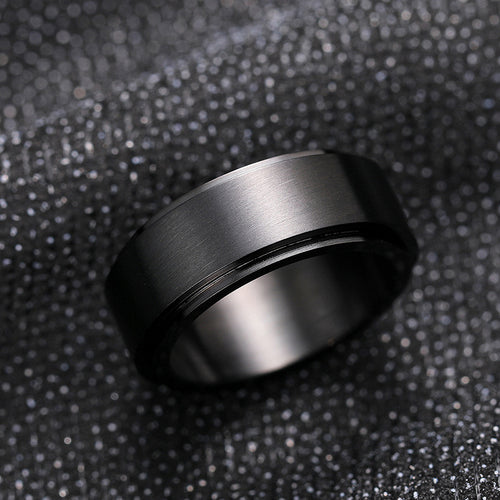 Black brushed spinner band ring angled on dark sequined fabric