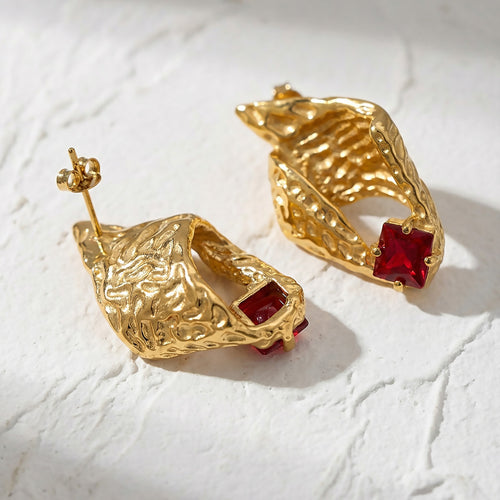On-ear view of textured shell red crystal earrings in main image 2.