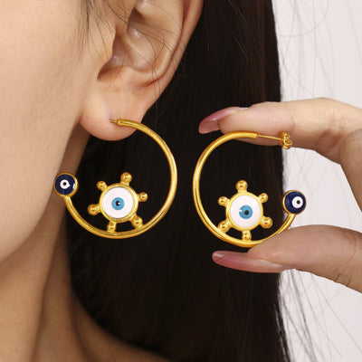 Model wearing gold C-hoop evil eye sun enamel earrings pair