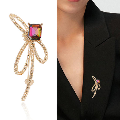 Gold multicolor rhinestone bow brooch product shot and worn on black blazer