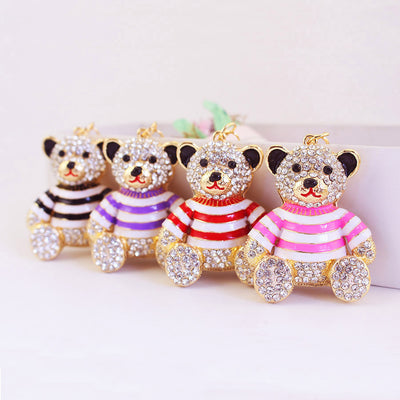 Four gold-tone rhinestone bears wear black, purple, red and pink striped shirts.