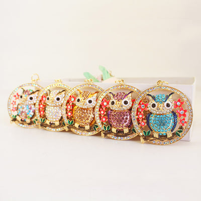 Five round owl pendants in different rhinestone colors arranged in a row.