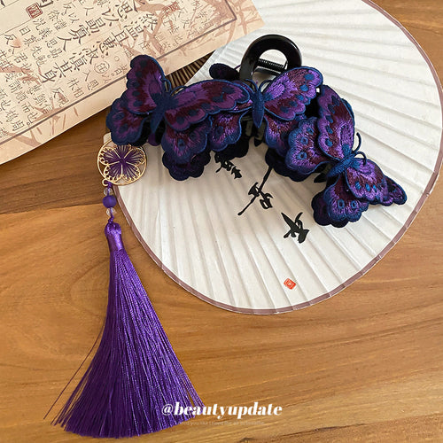 Purple butterfly claw clip with tassel on fan and calligraphy paper