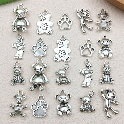 Antique silver bear charms arranged on a light background