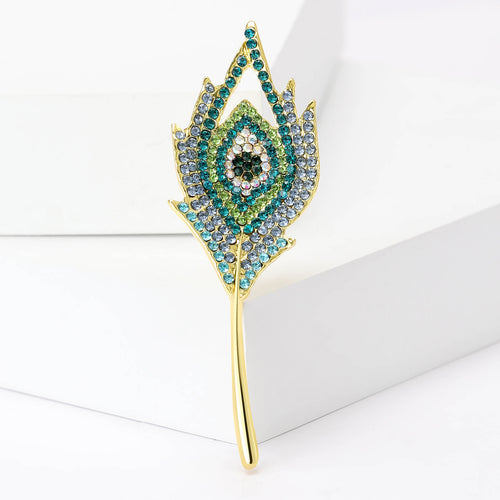 Close front view showing a long gold-tone feather with a colorful crystal eye pattern