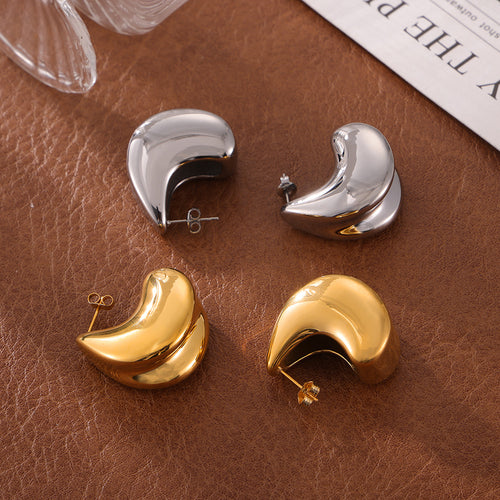 Close-up gold chunky teardrop stud earring on ear