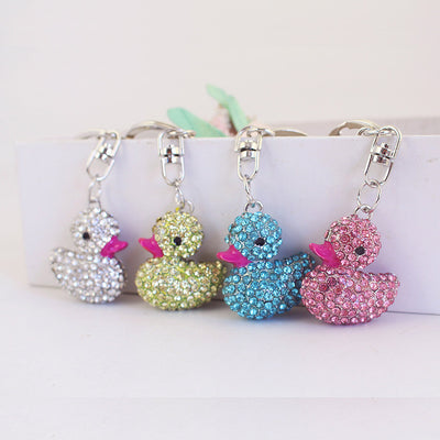 Four rhinestone duck keychains displayed in white, yellow-green, blue and pink.