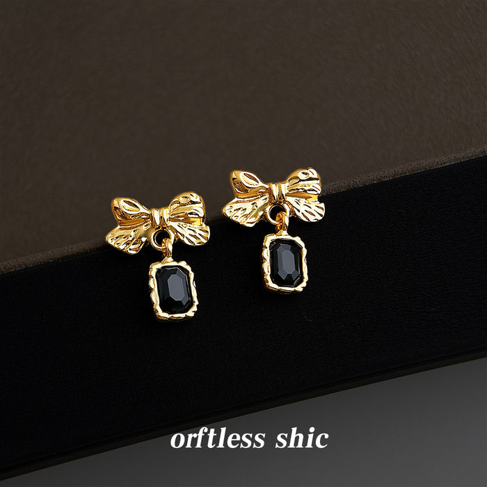 Gold Tone Textured Bow And Black Rectangular Stone Drop Earrings