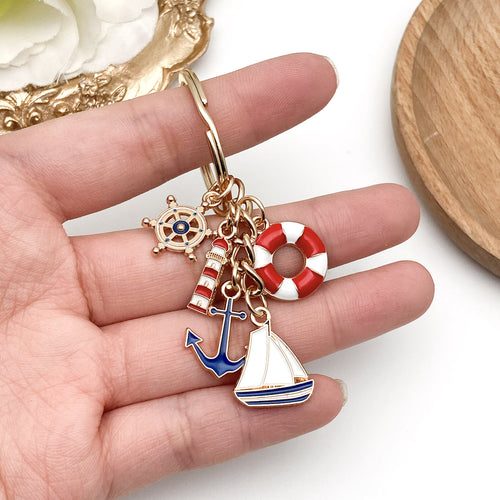 Alternate arrangement of the red blue nautical lighthouse anchor and sailboat keychain showing its hardware and charm de