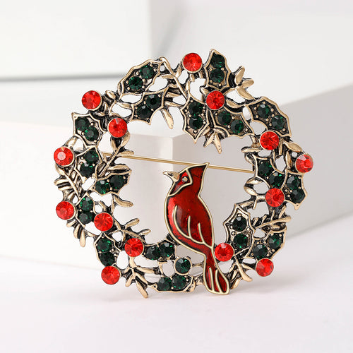 Close front view showing a red bird perched inside a leafy round wreath dotted with red stones