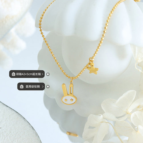 Gold ball chain bunny pendant on white decor with length and material labels