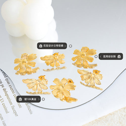 Gold flower stud earrings scattered on mirror with material caption tags