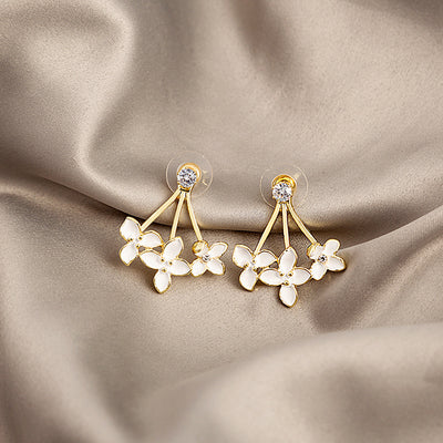 Gold white enamel flower cluster drop studs on beige satin fabric