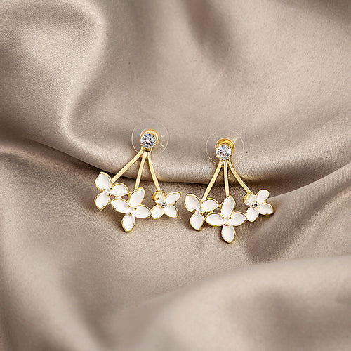 Gold white enamel flower cluster drop studs on beige satin fabric