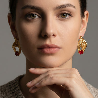 Display view of textured shell red crystal earrings in main image 1.