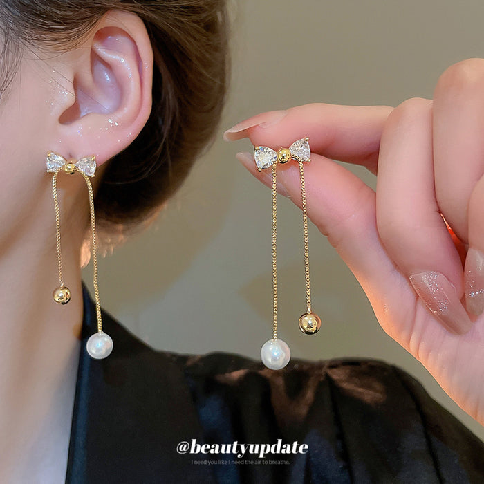 Crystal Bow and Pearl Drop Earrings with Polished Metal Details