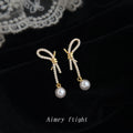 Gold Tone Clear Stone Bow Long Tail And White Pearl Stud Earrings view 1