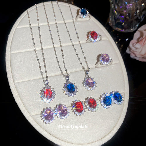 Silver oval halo necklace earring and ring sets in red blue and pink on tray