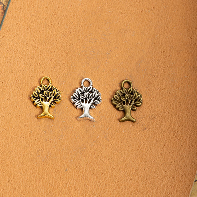 Main product image of the mini tree of life charm showing a small tree silhouette with open branches and a top loop