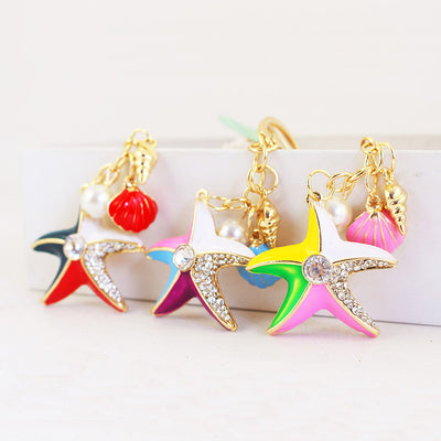 Three colorful starfish keychains displayed with shell charms and pearl-like beads.
