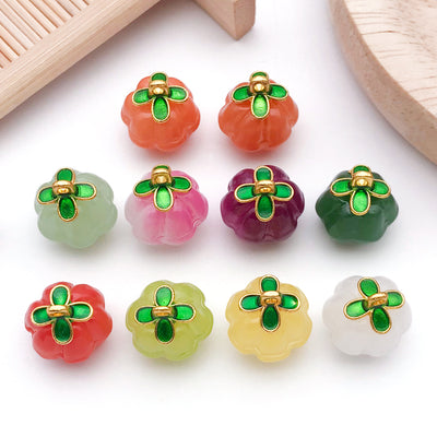 Metallic four-leaf clover and pumpkin charms arranged on a light background