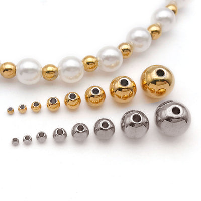 Gold-tone spacer bead beads arranged on a light background
