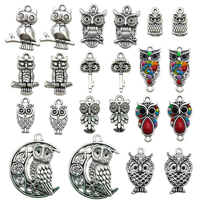 Antique silver bird charms arranged on a light background