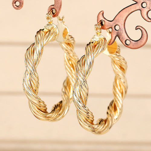 Gold Tone Twisted Rope Large Hoop Earrings Polished Statement Fashion Jewelry shown in a styled view