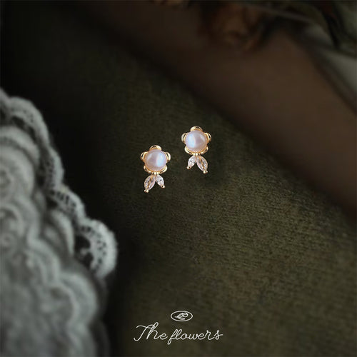 Gold-tone white-pearl-flower clear-leaf studs in the first product display.