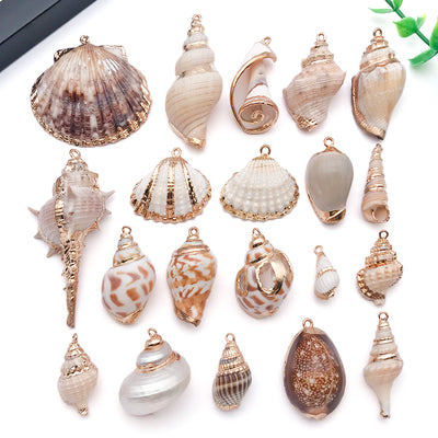 Gold-tone seashell charms arranged on a light background