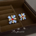 Gold Tone Blue Petal Red Center Flower Earrings In Clip And Stud Styles view 3