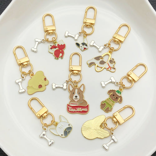Grouped sixteen jumping and playful dog clasp keychains arranged together on a styled display surface