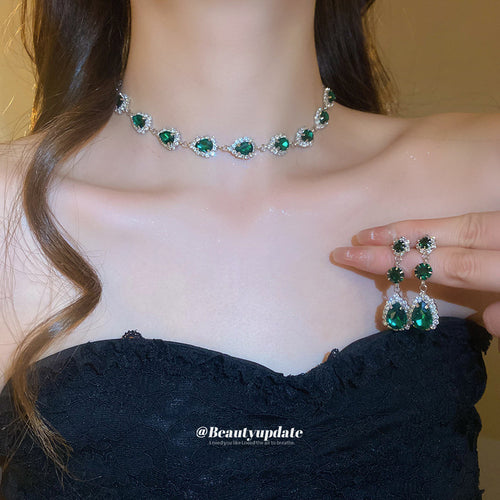 green teardrop crystal necklace and earrings displayed on a dark bust