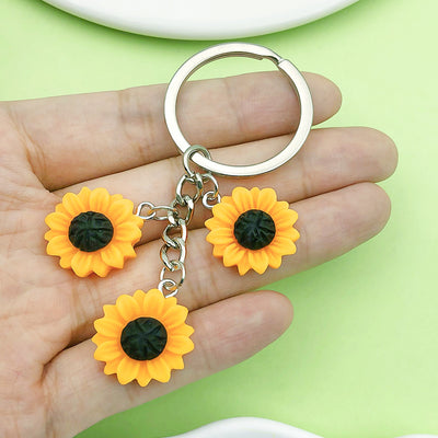 Image 1 showing a person holding two yellow flowers in their hand.