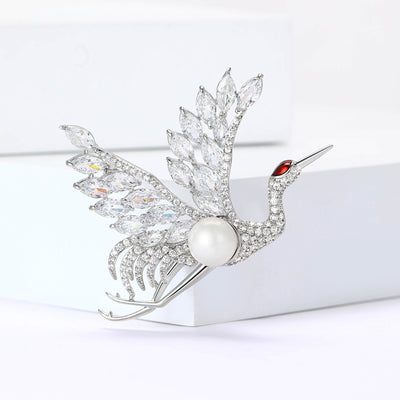Silver crystal crane brooch with pearl body on white blocks