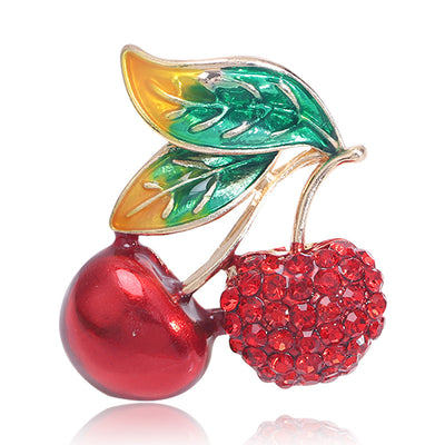 Front view of pair of red cherries with green leaves and one crystal-covered fruit