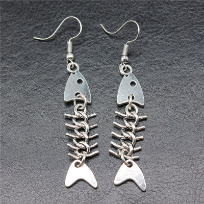 Close-up of jointed fish skeleton earrings showing jointed fish skeleton drops on fishhook ear wires