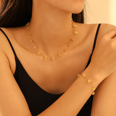 Model wearing yellow stone chip gold necklace and bracelet set