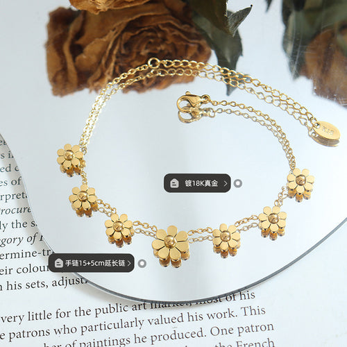 Gold daisy bracelet on mirror with dried roses and length plating labels
